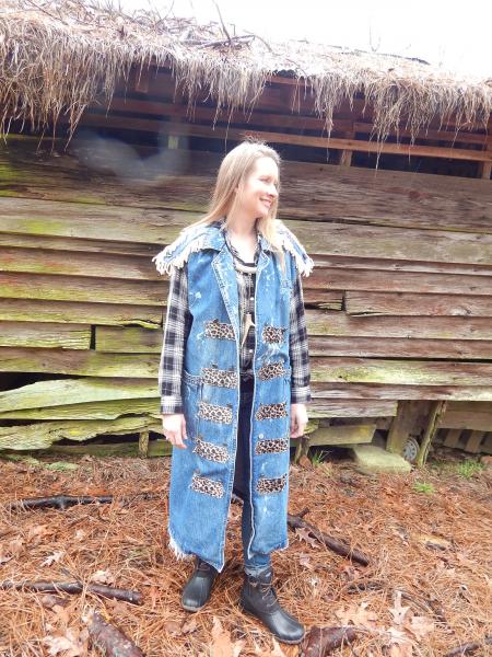 20208 Danielle Long Denim Band Coat/Vest has epaulets and animal print and leather trim. Coat vest has natural fraying. Only one is available in size medium.